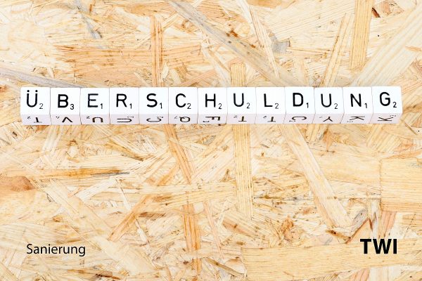 ueberschuldung-twi Das Wort Überschuldung mit Buchstabenwürfeln geschrieben. Darunter die Worte: Sanierung, TBI.
